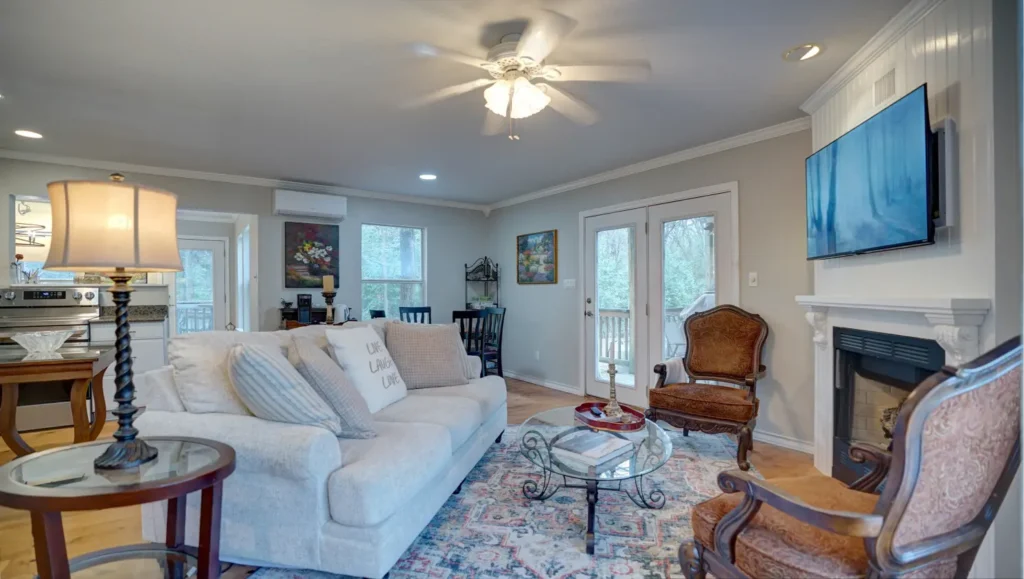 Living room with sectional sofa facing a wall-mounted TV and fireplace.